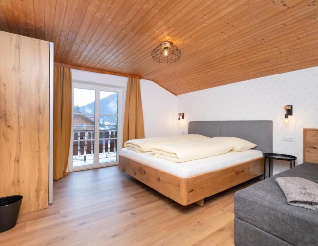 Geräumiges Schlafzimmer mit einem großen Doppelbett und direktem Zugang zu einem Balkon